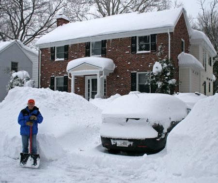 Man with snow shovel and car