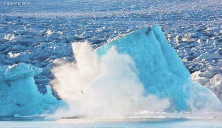 An immense chunk of ice calving away from lilliehookbreen (lilliehook glacier) and collapsing into the sea, on spitsbergen in the svalbard archipelago, norway.