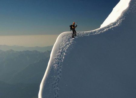 Man Climbing Snowy Mountain